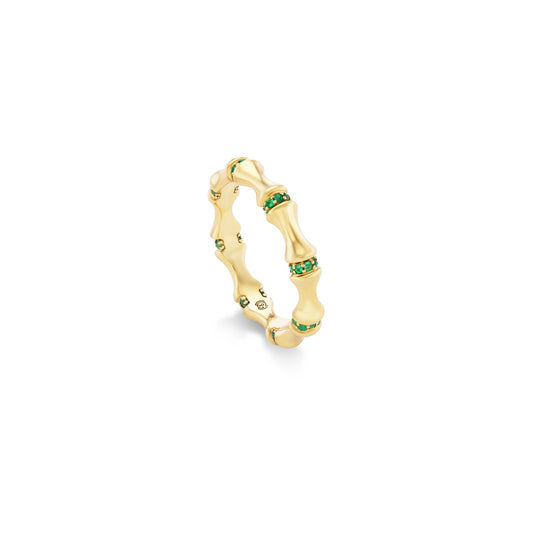 Gold ring with emerald stones on a white background