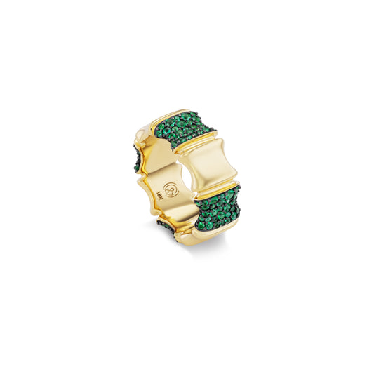 Gold ring with green gemstones on a white background