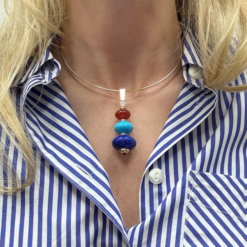 Necklace with colorful beads worn by a person in a blue and white striped shirt