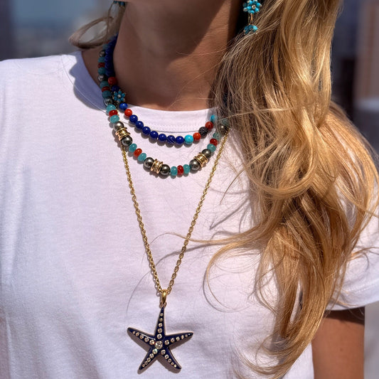 Woman wearing white top and necklaces.
