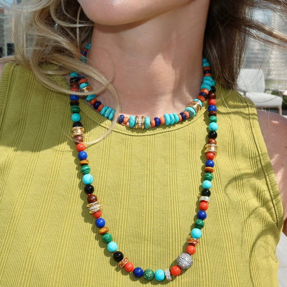 Woman wearing green and beaded necklaces.