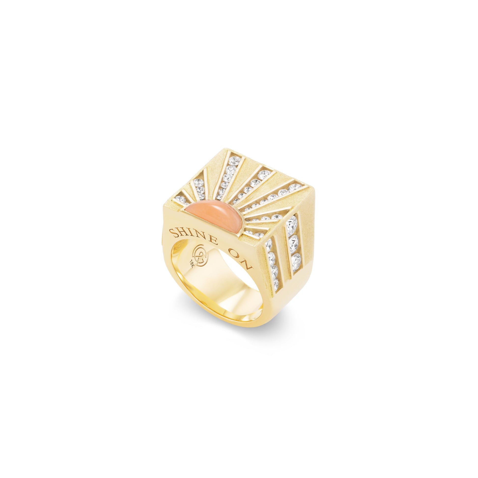 Gold ring with coral and diamond sunburst design and 'Shine On' engraving on a white background