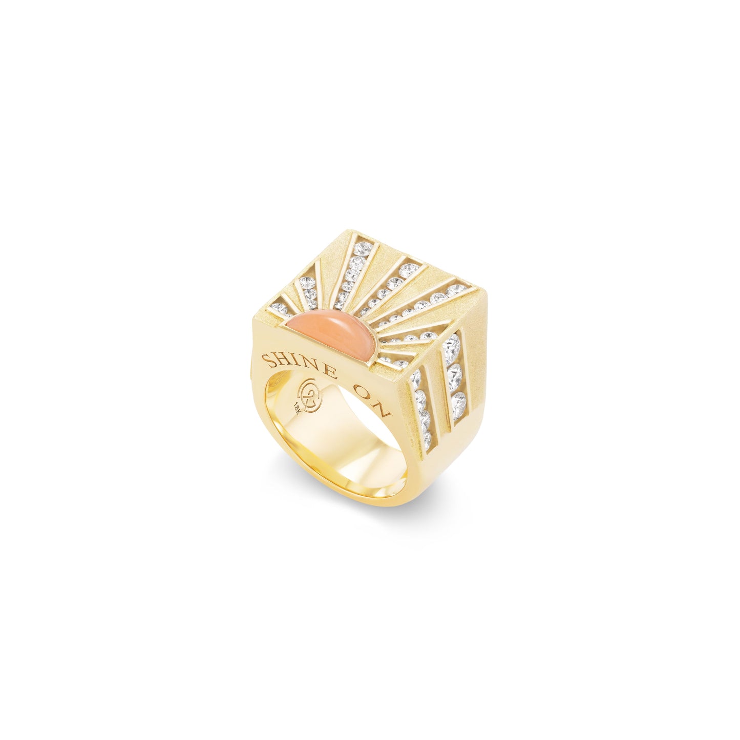 Gold ring with coral and diamond sunburst design and 'Shine On' engraving on a white background
