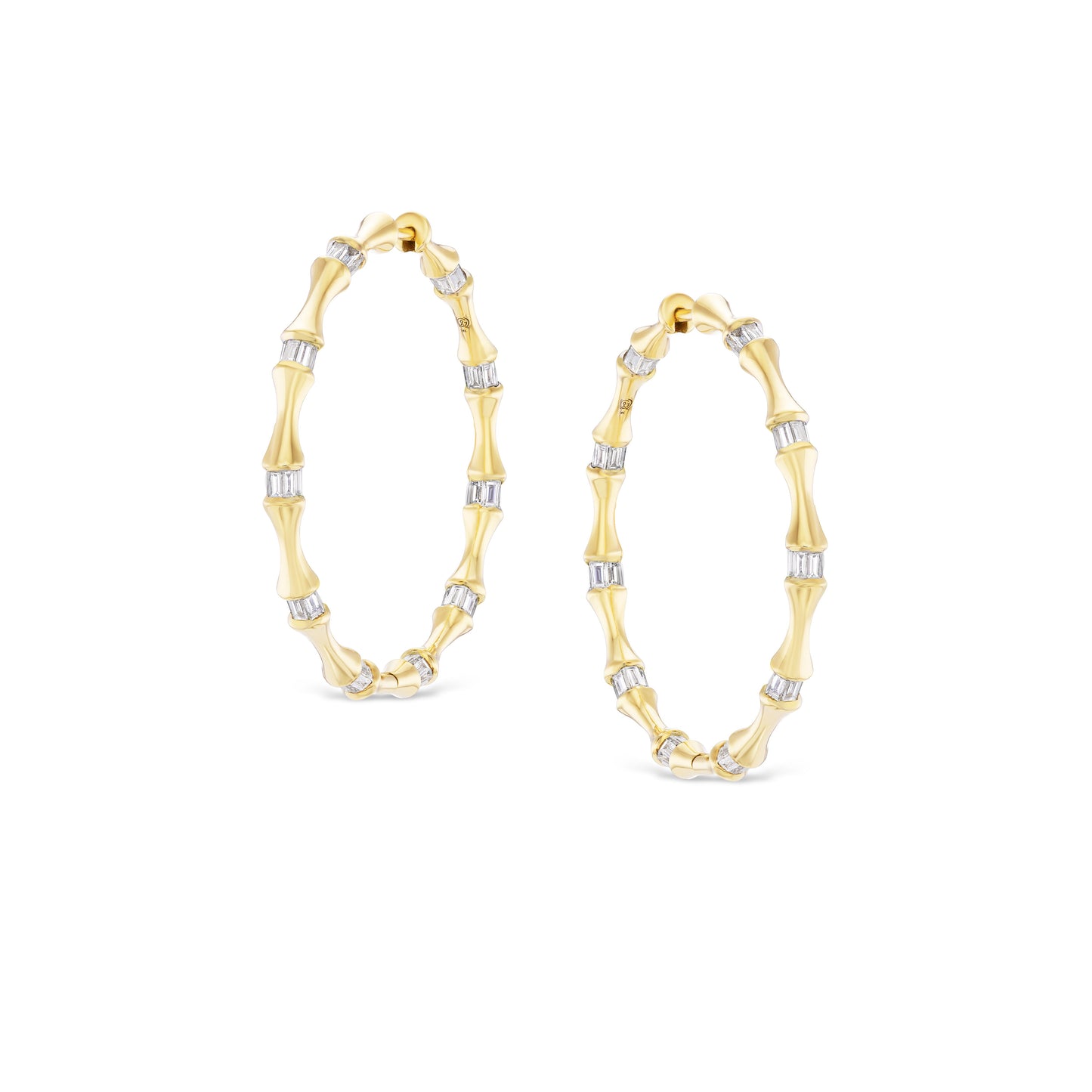 Gold hoop earrings with a bamboo design on a white background