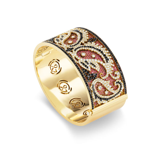 Gold cuff bracelet with intricate paisley design on a white background