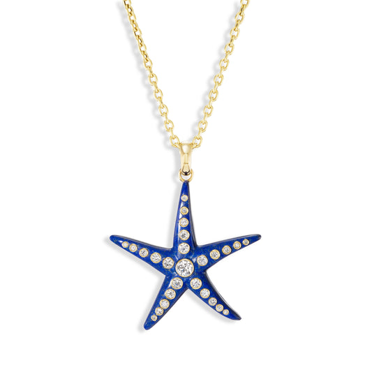 Starfish pendant necklace with blue enamel and clear gemstone on a gold chain against a white background