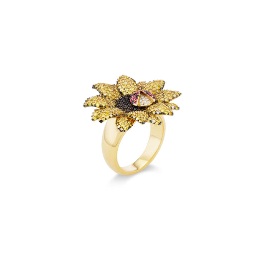 Gold ring with a sunflower design and gemstones on a white background