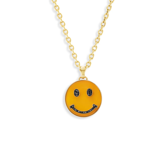 Gold necklace with a smiley face pendant on a white background