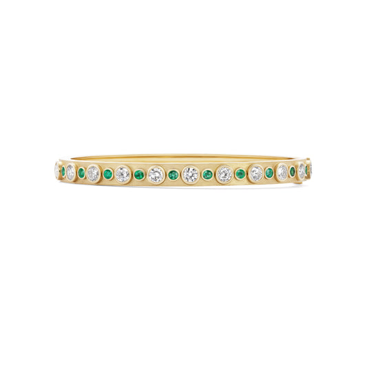 Gold bracelet with green and clear gemstones on a white background