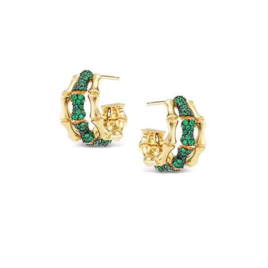 Gold hoop earrings with green gemstones on a white background