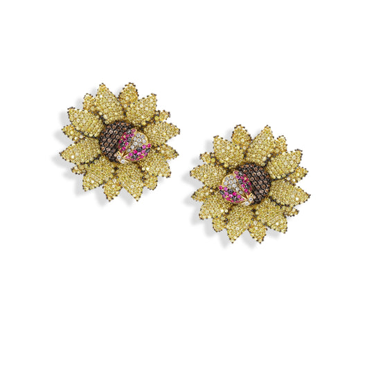 Gold sunflower-shaped earrings with gemstones on a white background