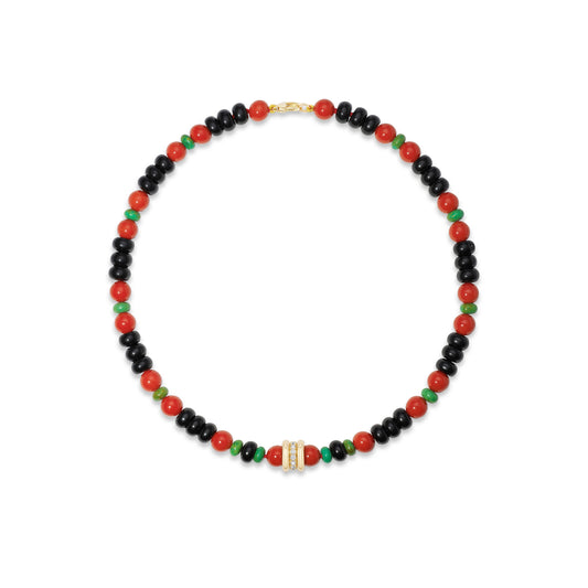 A beaded necklace featuring alternating black and red beads, accented with small green beads and a central gold-toned rectangular charm with clear stones, displayed on a clean white background.