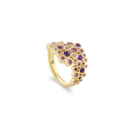 Gold ring with purple gemstones on a white background